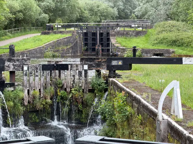 Water spilling over a lock gate on a steep English canal flight, like the Caen Hill locks outside Devizes