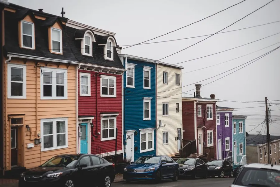 Cars parked on a sloping residential driveway outside older houses
