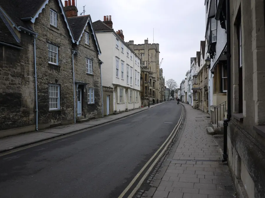 Narrow street of historic limestone houses with stone pavements, typical of the conservation areas in Cirencester