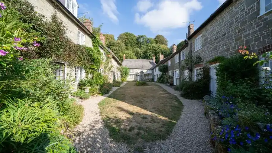 English stone cottages with a traditional gravel path running between planted borders