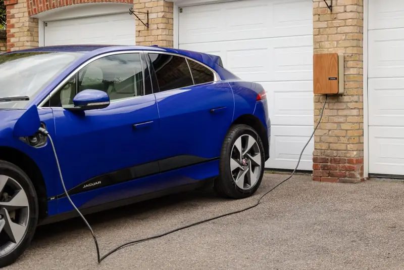 Electric car charging from a wall mounted home charge point on a domestic driveway