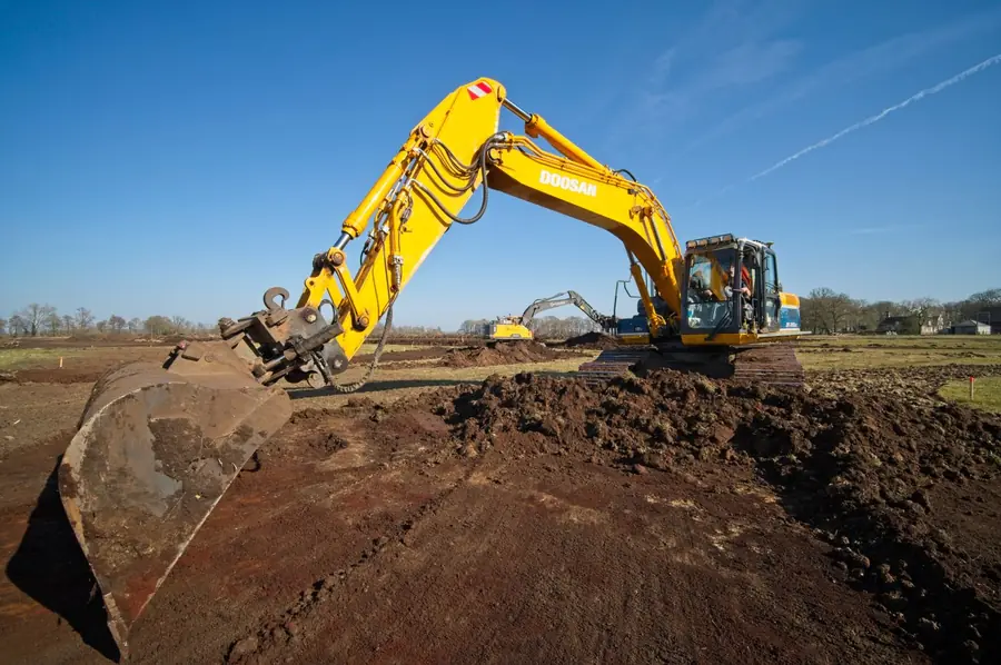 Excavator digging out soil during groundworks, the stage that drives most of a Marlborough driveway quote