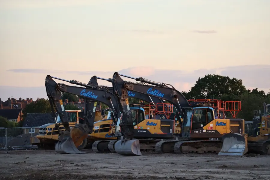 Row of excavators parked on a new housing development site in England, like the Steadings build south of Chesterton in Cirencester