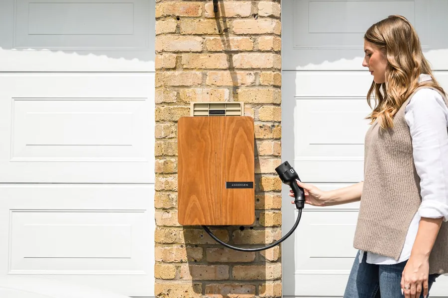 Wall mounted home EV charger on a brick house wall above a driveway, the sort of installation a Swindon landlord needs to plan cable routes for