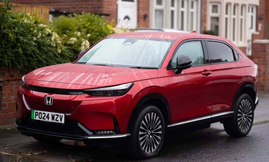 Modern SUV with UK registration plates parked outside a British brick house