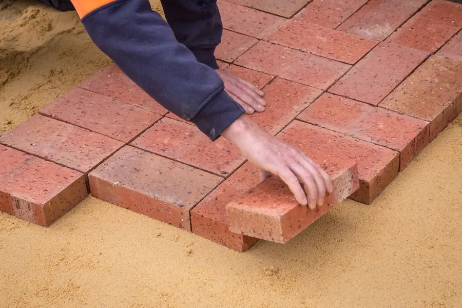 Installer working on a sloping surface during a driveway installation