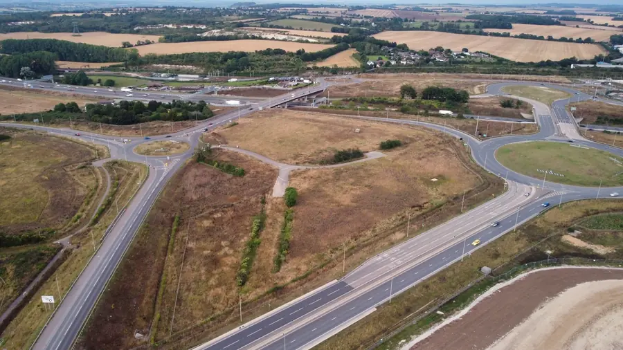 Aerial view of a motorway junction and slip roads cutting through farmland, the sort of route used to reach Royal Wootton Bassett from Swindon