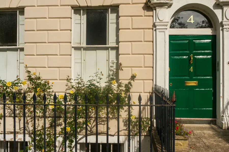 Period house with iron railings and a painted front door behind a small front garden, similar to the older villas in Devizes
