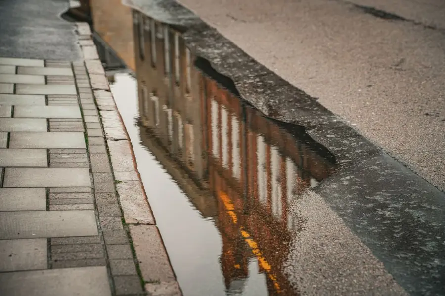 Rainwater standing at the kerb edge on a residential street