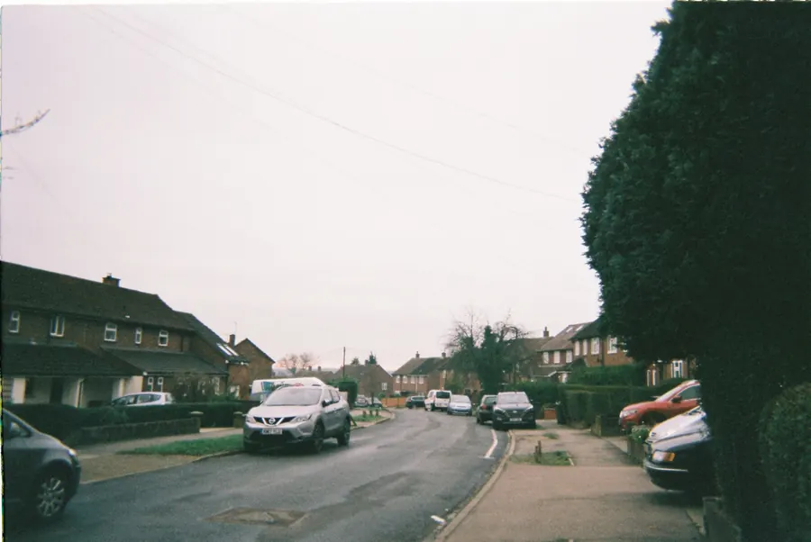 Postwar semi-detached houses and kerbed pavement on a Chippenham residential street
