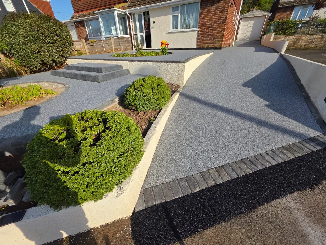 Aerial view of a detached property in Swindon with a large silver grey resin bound driveway and planted border