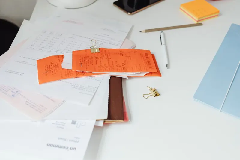 Guarantee paperwork and receipts for a resin driveway installation kept together on a desk