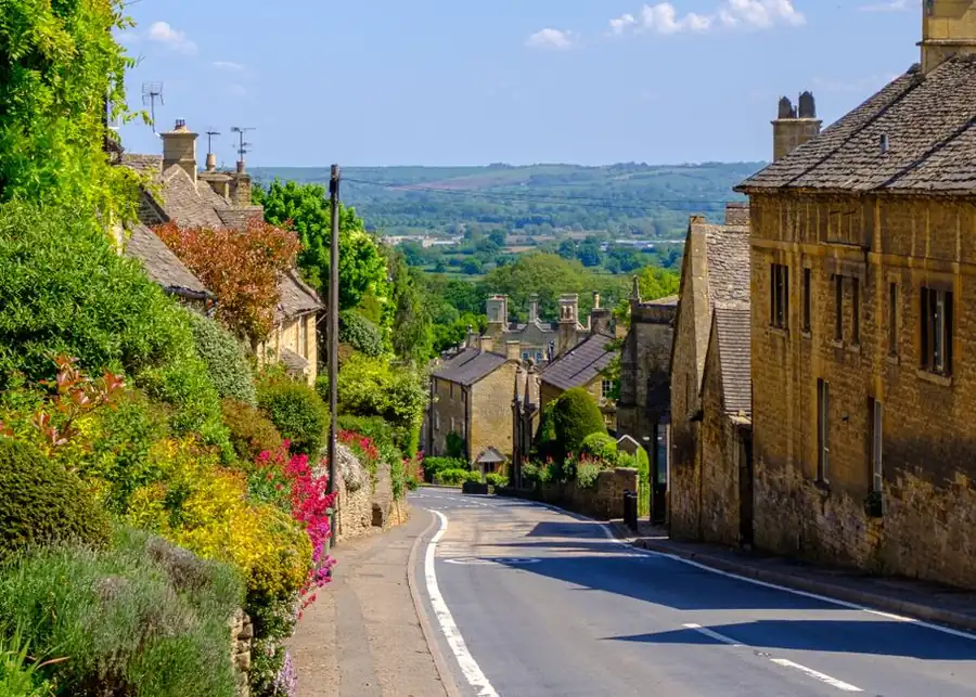 Sloping street of stone houses with driveways falling towards the road