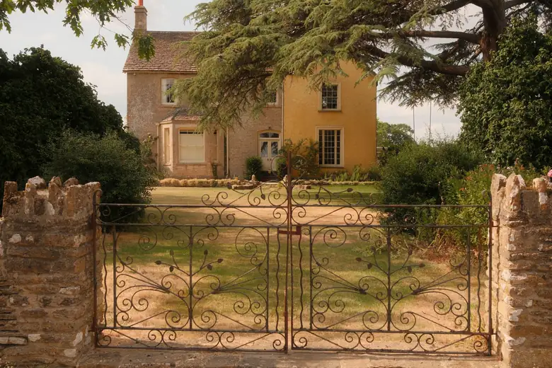 Stone gate piers and iron gates at the entrance to a Wiltshire property near Calne