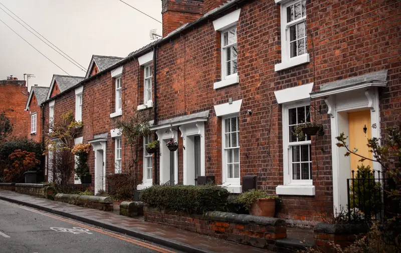 Row of English brick houses with shallow front gardens on a residential street, typical of older Swindon housing