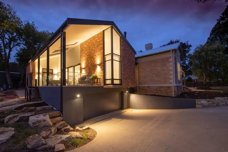 Lit walkway beside a house at dusk, showing the effect of low level lighting on an approach and driveway